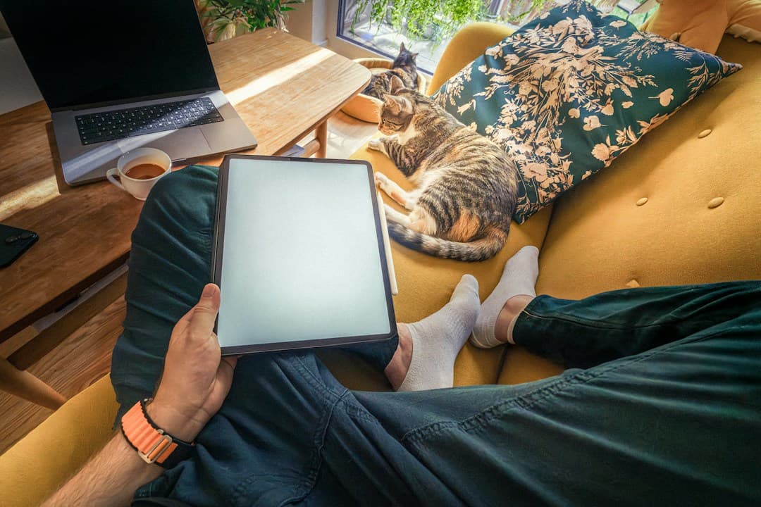 Personne assise sur un canapé avec une tablette pour utiliser Smarters Player Lite